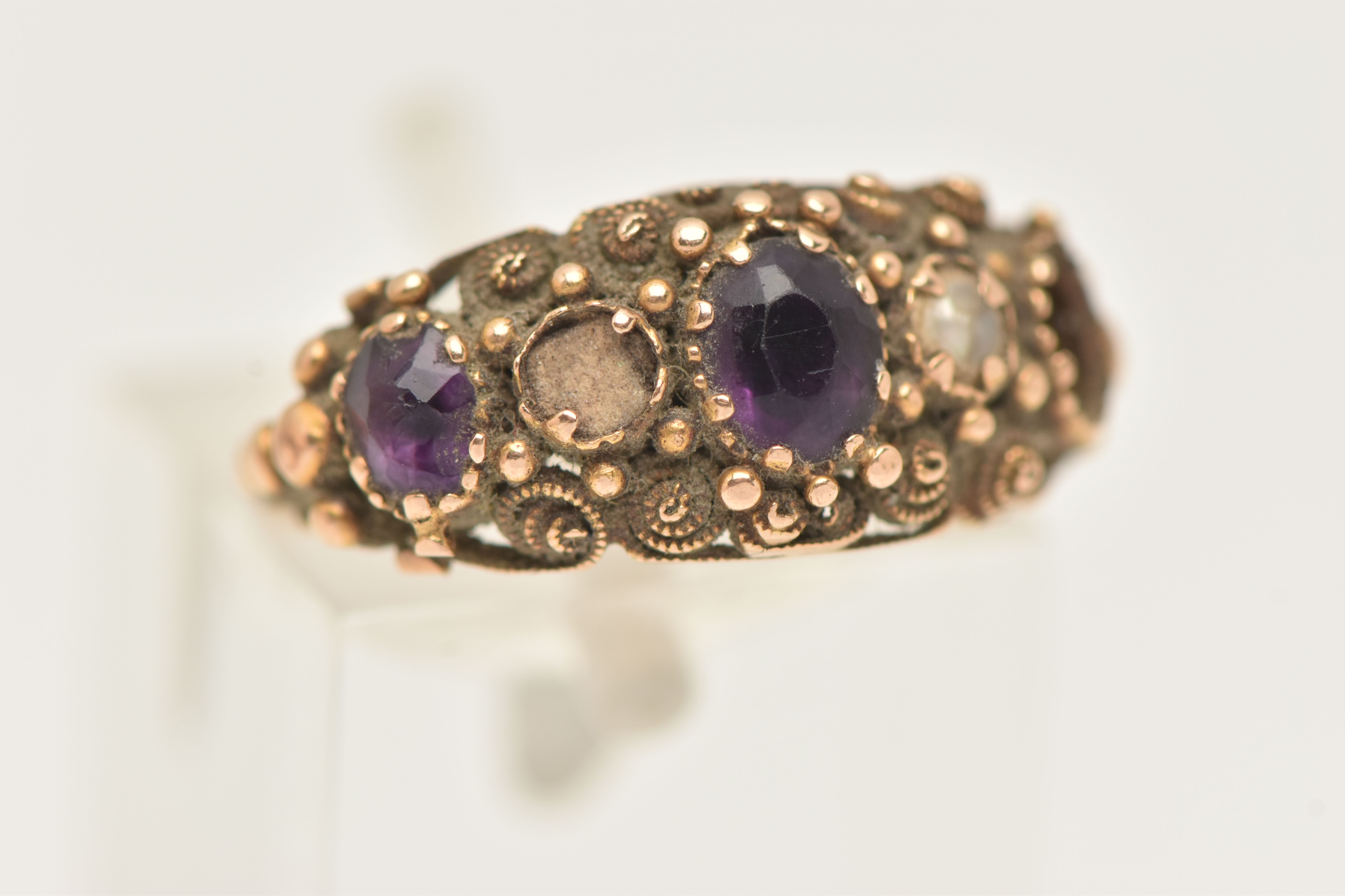 A YELLOW METAL GEM SET RING, AF set with two oval cut amethysts (one missing) and a single split - Image 4 of 6