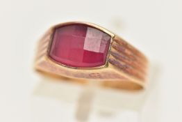 A YELLOW METAL FANCY CUT RUBY RING, ruby collet set to the textured shoulders and polished band,