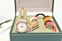 A CASED GUCCI BANGLE WATCH WITH ELEVEN COLOURED INTERCHANGABLE BEZELS, WITH BOOKLET AND INTERNATIOAL