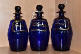 A SET OF THREE EARLY 19TH CENTURY BRISTOL BLUE GLASS BARREL SHAPED DECANTERS, with original