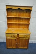 A MODERN PINE DRESSER, the three tier plate rack, atop a base fitted with two drawers, above two