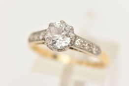 A YELLOW METAL GEM SET RING, set with a colourless circular cut stone assessed as moissanite (
