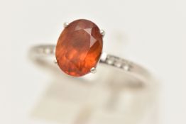 A 9CT WHITE GOLD GEM SET RING, set with a central oval cut Citrine, four claw set in a raised mount,