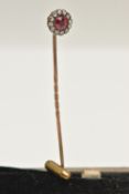 A YELLOW METAL CLUSTER STICK PIN, of a circular form set to the centre with a garnet topped red