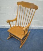 A BEECH ROCKING CHAIR, with scrolled armrests, turned supports, and legs, width 57cm x depth 75cm