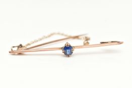 A GEM SET BAR BROOCH, a rose metal bar brooch, prong set with a single oval cut sapphire,