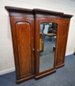 A VICTORIAN FLAME MAHOGANY BREAKFRONT TRIPLE DOOR WARDROBE, with fielded panel doors, flanking a