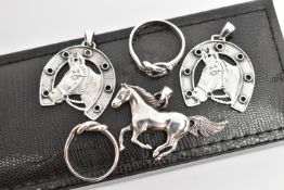 FIVE WHITE METAL JEWELLERY ITEMS, to include two horse shoe and head pendant, a running horse