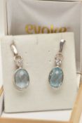 A PAIR OF TOPAZ EARRINGS, faceted oval topaz stones collet set with square cut cubic zirconia