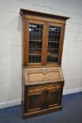A 20TH CENTURY OAK BUREAU BOOKCASE, fitted with double lead glazed doors, atop a base with a fall