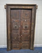 A HEAVY CARVED EASTERN HARDWOOD DOUBLE DOORS, within a moulded frame, the doors with reeded
