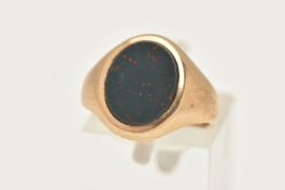 A YELLOW METAL BLOODSTONE SIGNET RING, of an oval form, set with a polished bloodstone inlay, to a