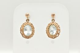 A PAIR OF YELLOW METAL GEM SET EARRINGS, oval cut light blue topaz, prong set in yellow metal with