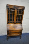 A 20TH CENTURY OAK BUREAU BOOKCASE, with double glazed doors, atop a base with a fall front door,