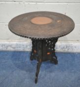 AN ANGLO INDIAN HARDWOOD CARVED TABLE, with repeating foliate and elephant details, a central copper