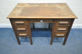 AN EARLY 20TH CENTURY OAK KNEEHOLE DESK, fitted with seven assorted drawers, width 115cm x depth
