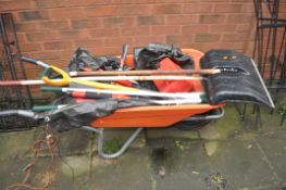 A PLASTIC WHEELBARROW CONTAINING GARDEN TOOLS including a stainless steel spade, tree loppers, a