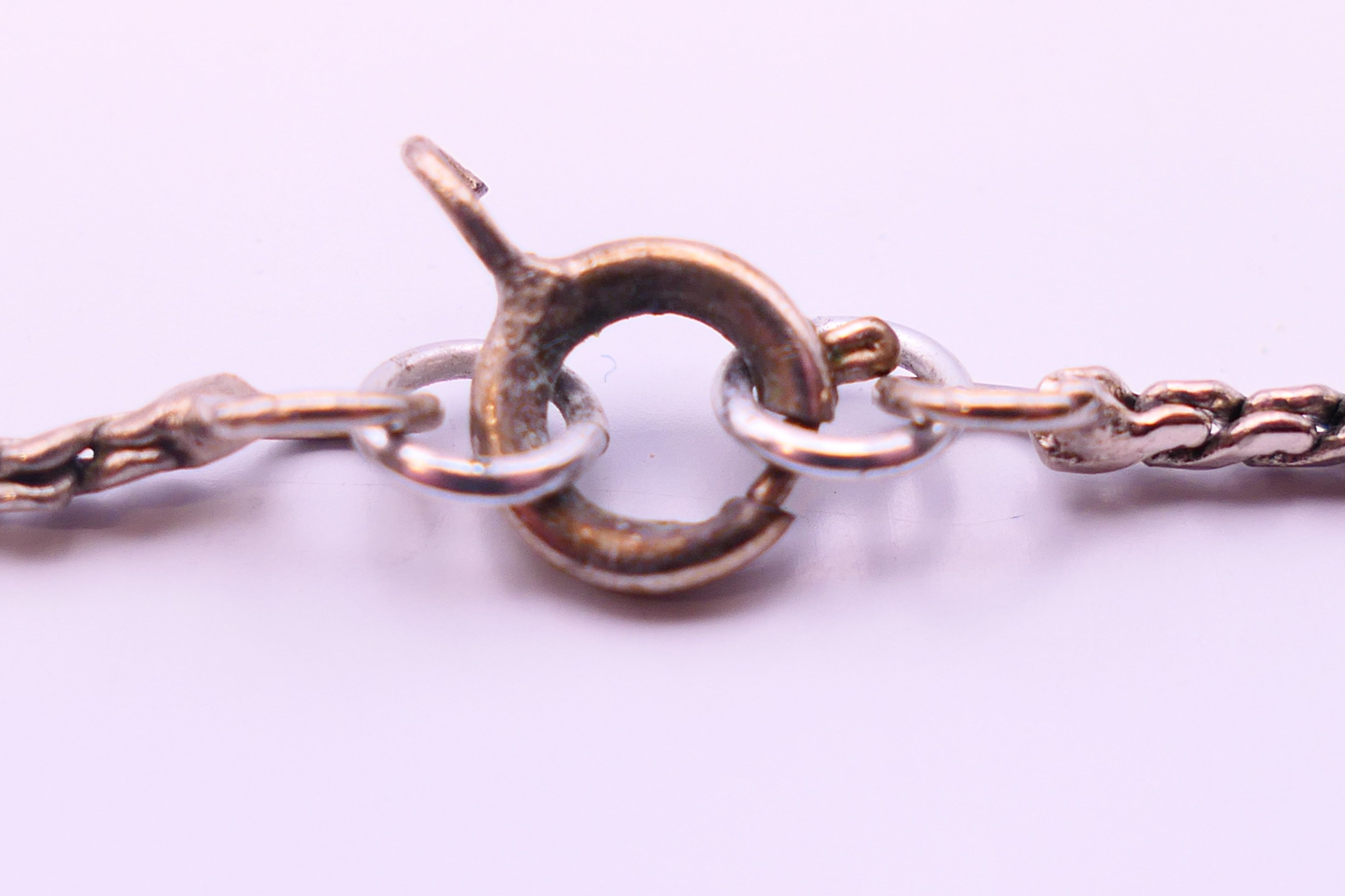 A silver crucifix on a silver chain. - Image 5 of 6