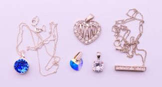 Five silver stone set pendants, two with silver chains.