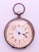 A silver pocket watch. 3.5 cm diameter.