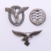 Three WWII German insignia. 8.5 cm x 4 cm, 5.5 cm x 6.5 cm and 4.5 cm diameter.