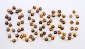 A string of pearl and tiger's eye beads. 120 cm long.