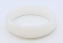 A plain white jade bangle. 6.25 cm internal diameter, 8.25 cm external diameter.