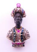 A gemstone and diamond set blackamoor brooch, circa 1950, the headdress and tunic set with coral,