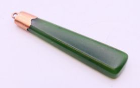 A jade pendant, engraved JK 15.04.24. 5 cm high.