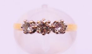 An 18 ct gold three stone diamond ring, hallmarked for London. Ring size L.