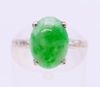 A 14 ct white gold single stone jade ring. Ring size J.