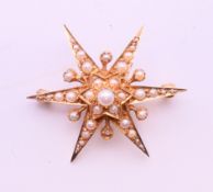A 9 ct gold and seed pearl star form brooch. 4 cm diameter. 6.8 grammes total weight.