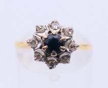 An unmarked gold and sapphire ring. Ring size M/N.