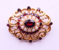 A 10 K gold, garnet and seed pearl brooch. 3.5 cm x 2.75 cm. 8.5 grammes total weight.