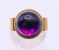 An unmarked gold cabochon amethyst ring. Ring size K/L.