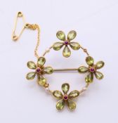 A 15 ct gold circular brooch with four gem set flowerheads. 3.5 cm diameter. 5.