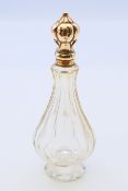 An 18 ct gold topped glass scent bottle. 10.5 cm high.