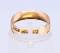 A 9 ct gold wedding band. Ring size L.