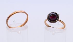 A 9 ct gold band and an unmarked gold cabochon set ring.