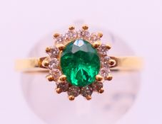 An 18 ct gold diamond and emerald ring. Ring size O.