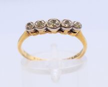 An 18 ct gold five-stone diamond ring. Ring size O.