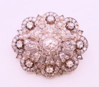 A Victorian diamond pendant/brooch, the central stone approximately 1.25 carats, flanked by eight .
