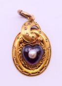 A gold, garnet and pearl heart-shaped pendant, in a heart shaped box. 3 cm high. 3.