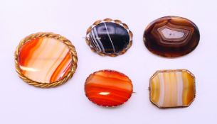 Five agate brooches. The largest 5 cm x 5.5 cm.