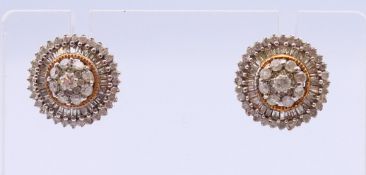 A pair of 9 ct gold diamond earrings. 1.25 cm diameter.