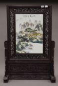 A Chinese porcelain screen on a wooden stand. 67.5 cm high.