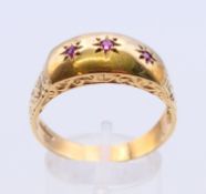 A 9 ct gold three stone ruby ring. Ring size Y.