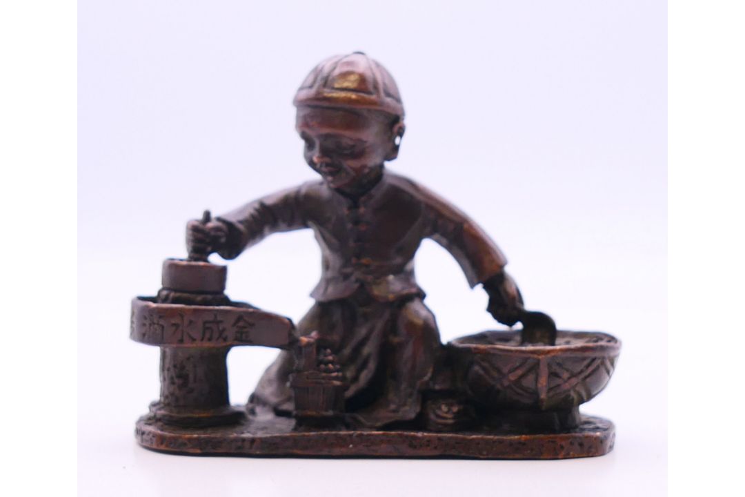 A bronze model of a boy cooking. 7 cm wide. - Image 1 of 4