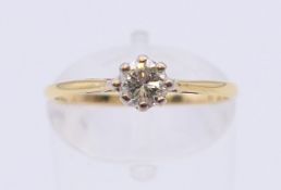 An 18 ct gold and platinum diamond solitaire ring. The claw set stone spreading to 0.25 carat.