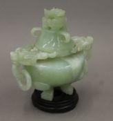 An early 20th century Chinese pale green jade censer with lid and wooden base,